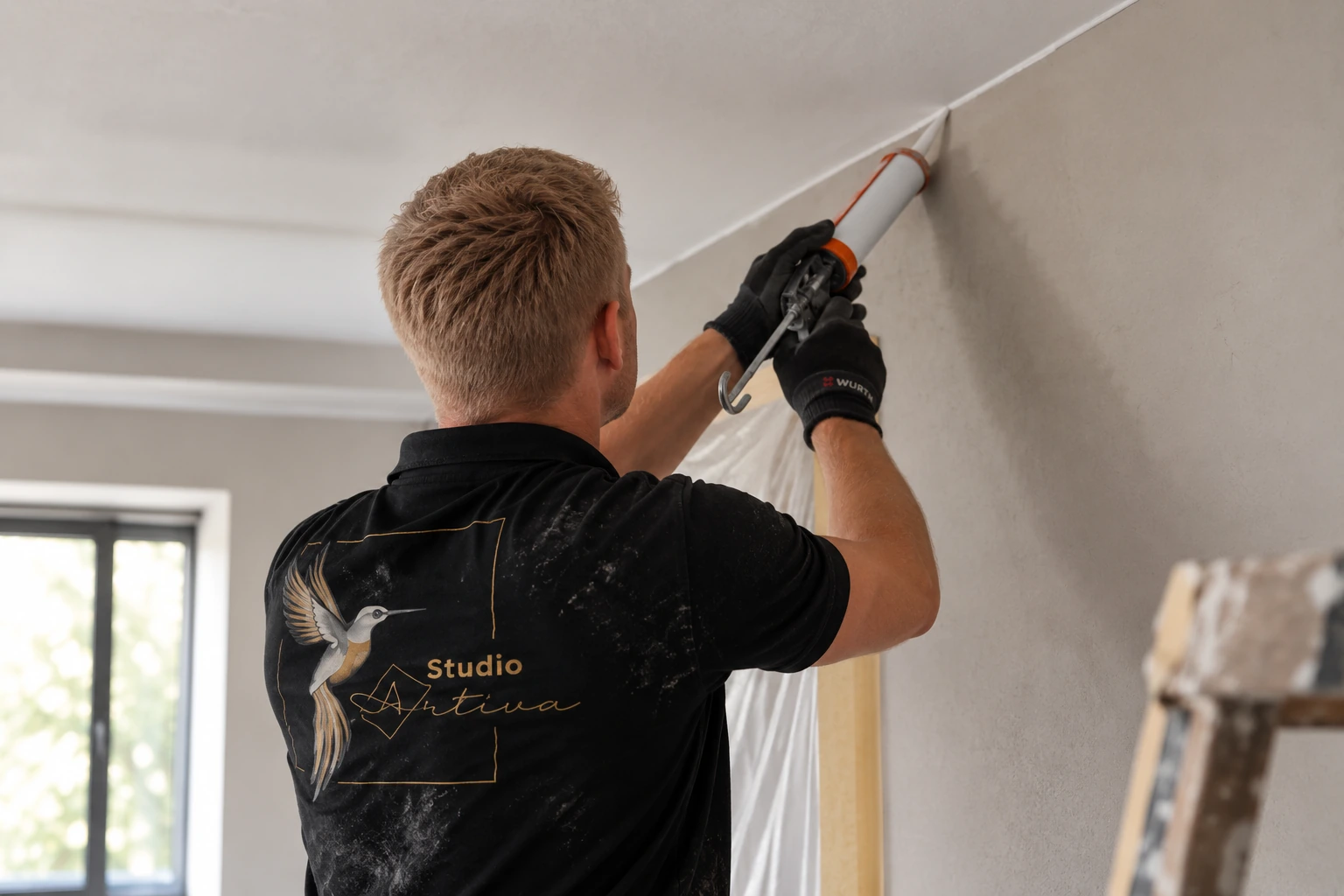 Schilder van Studio Artiva brengt kit of primer aan langs het plafond