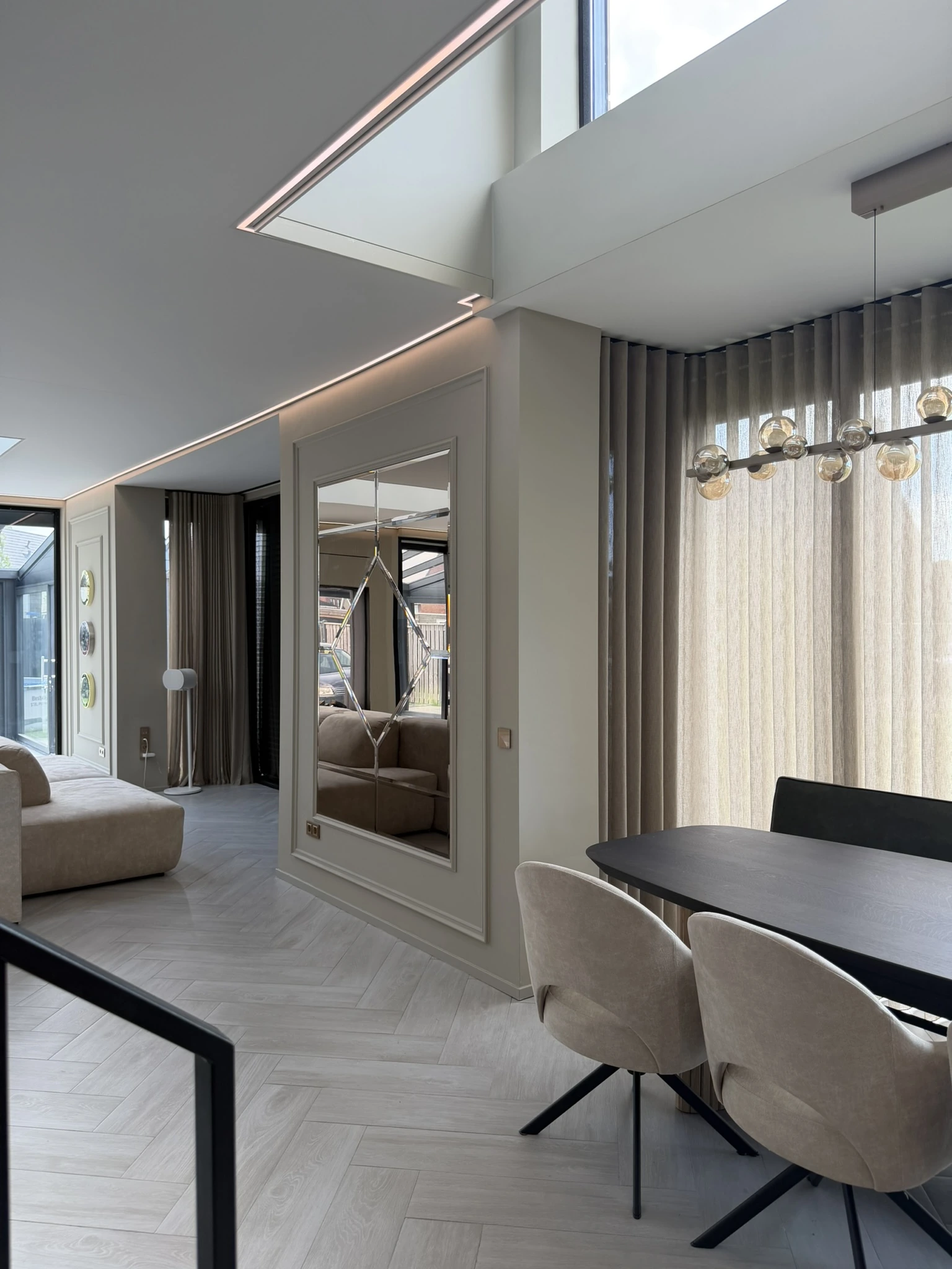 Hoge spiegel in een wandpaneel naast een eettafel