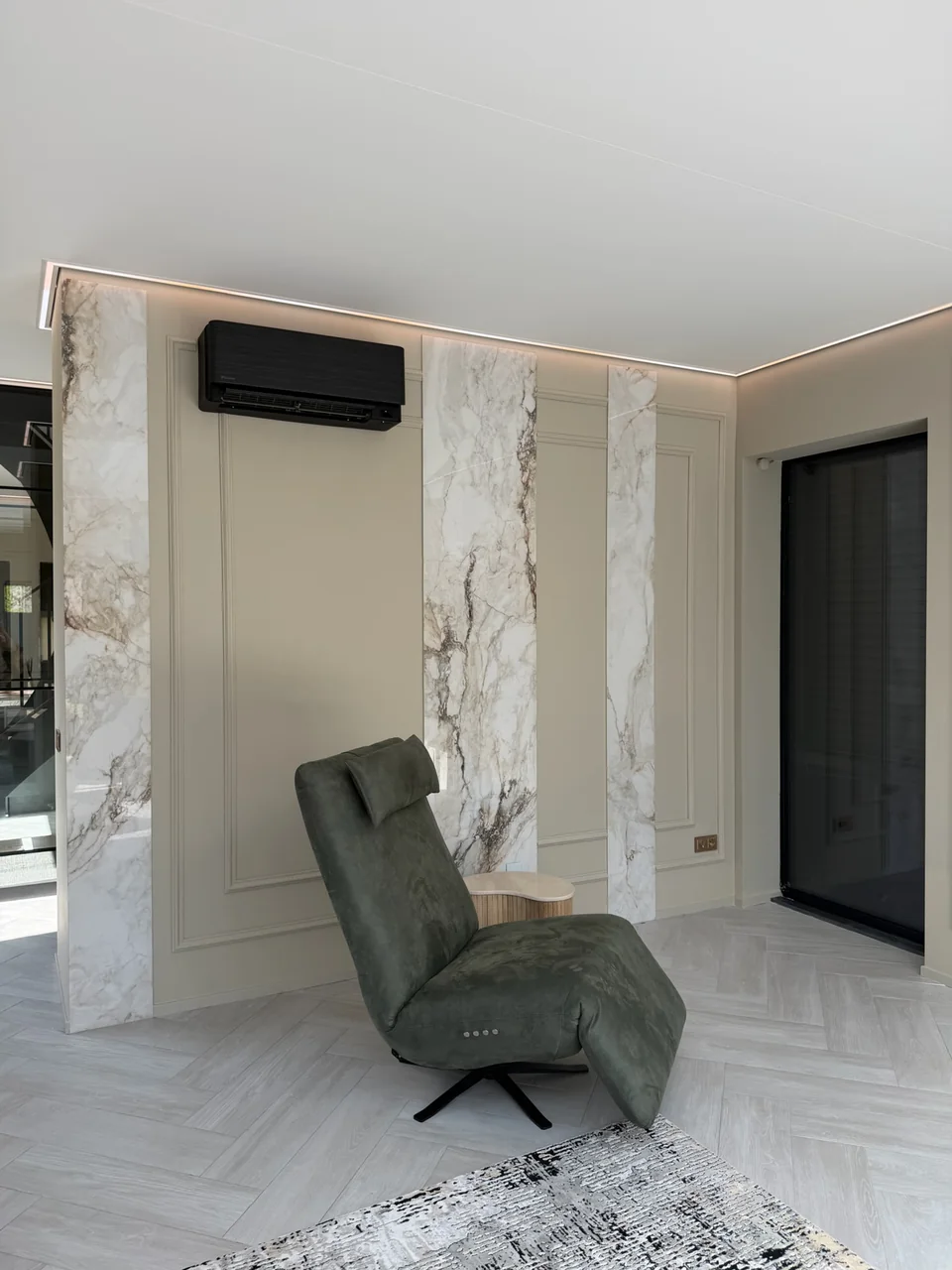 Sierlijsten op kleur rondom bestaande marmerplaten en airconditioning naast een fauteuil